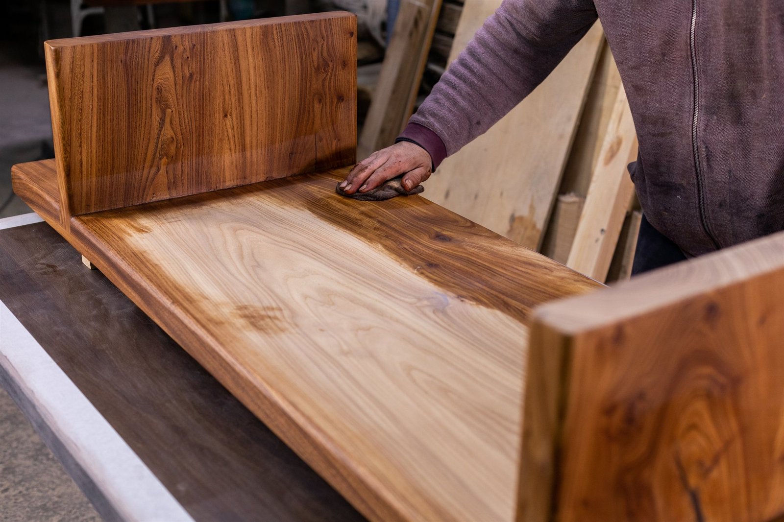 Master carpenter hand staining custom architectural woodwork